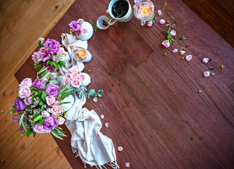 Flatlay of wooden table top surrounded by fresh spring flowers - roses, spa, bridal, spring vibes