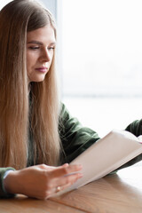 The girl is reading a book. The student is studying scientific literature. Leisure and rest.