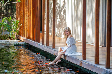 Woman relaxing at a luxury spa, barefoot on a wooden bridge
