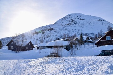 Snowy scenes in Hovden, Norway. Ski tracks on the ground, with Mountains and trees behind. Snow covered houses and blue skies. Bluebird weather. 