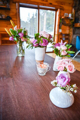 white vases with roses in a wooden cabin - spring decoration