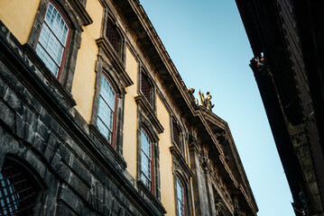 Yellow facade of the S&atilde;o Bento monastery with a statue on top. Porto, Portugal
