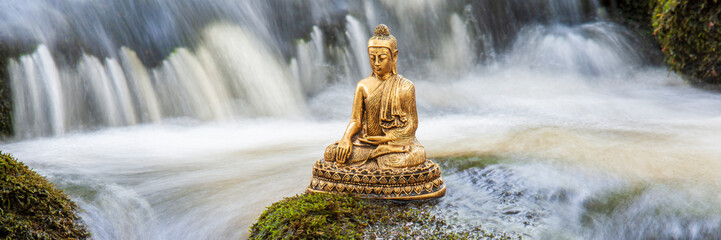 Buddha sculpture sitting in flowing water cascade