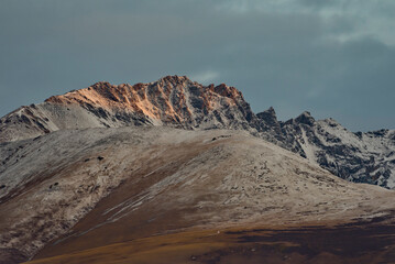 Russia. The South of Western Siberia, the Altai Mountains. The peaks of the North Chui mountain range illuminated by morning sunlight along the Chui tract near the village of Kurai.