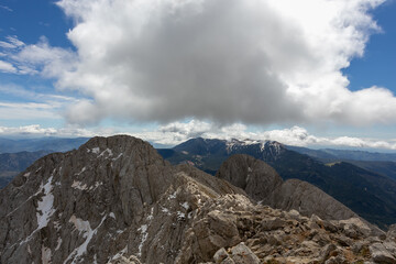 Picos de una montaña con nubes y sol