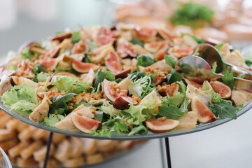 Salad with figs and arugula on a buffet table

