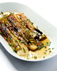 Leeks fried and poached in wine and butter sprinkled with finely chopped parsley. The perfect appetizer for a fish