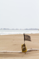 Obraz premium Bandera vieja e irreconocible ondeando en la playa con viento