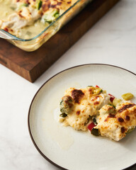 Baked chicken breast with vegetables under bechamel sauce. 