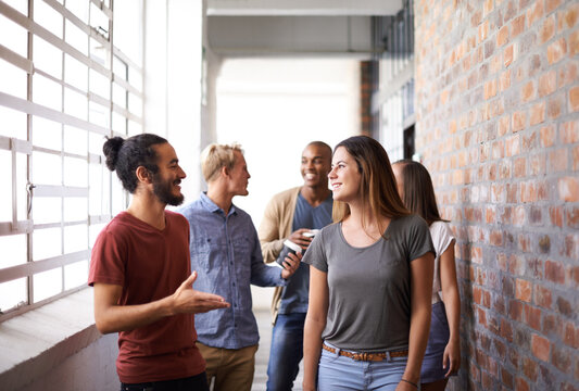 Catching Up On The Way To Class. Shot Of A Diverse Group Of University Friends Talking In A Hallway.