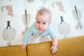 Portrait of charming Caucasian baby toddler with blue eyes in home in children room