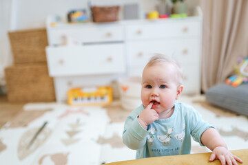 Portrait of a cute cheerful baby toddler and a baby synthesizer in the background