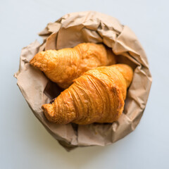 croissants in a paper bag on a white background.