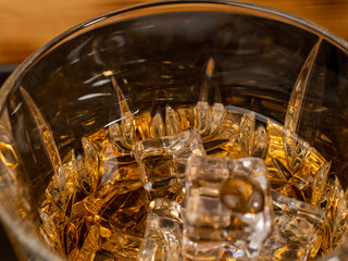 A glass of cognac with ice cubes. A glass of whiskey or bourbon with ice. Close-up.