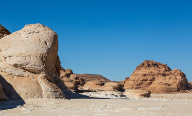 Sinai desert. Yellow and orange sandstone textured carved mountain, bright blue sky. Egyptian desert landscape. Sinai peninsula, Egypt