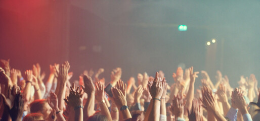 A crowd of people celebrating and partying with their hands in the air to an awesome band. This concert was created for the sole purpose of this photo shoot, featuring 300 models and 3 live bands. All