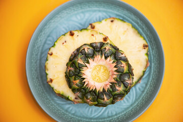 pineapple rings on a plate on a bright yellow background