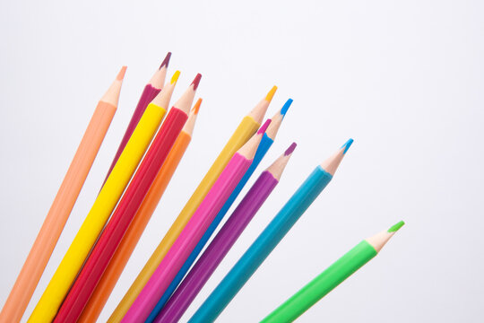 Different colors pencils - art card with drawing stationery on white background