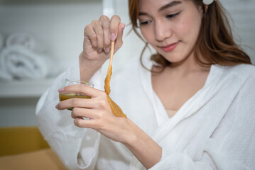 Close up images, hands of an Asian women, attractive and young applying herbal salt to make her own hand spa. woman and home spa concept.
