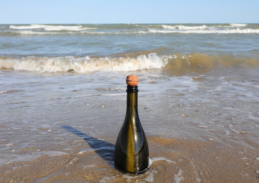 Bottle of green green on the rive of the sea with cork cap
