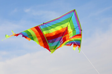 big kite with rainbow colors flies tied on string