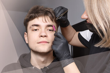 A real young man with brown eyes takes an eyebrow correction procedure. Eyebrow stylist shapes...