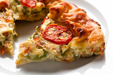 Torta salata a base di pasta sfoglia con ricotta, zucchine e pomodorini, cibo vegetariano 