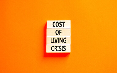 Cost of living crisis symbol. Concept words Cost of living crisis on wooden blocks. Beautiful orange table orange background. Business cost of living crisis concept. Copy space.