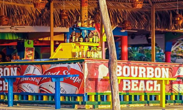 Negril, Jamaica - May 24. 2010: Colorful jamaican caribbean reggae bamboo wood bar on Bourbon beach in rasta colors
