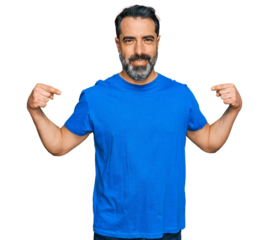 Middle aged man with beard wearing casual blue t shirt looking confident with smile on face, pointing oneself with fingers proud and happy.