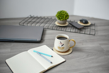 Coffee mug, laptop and notebook in the office