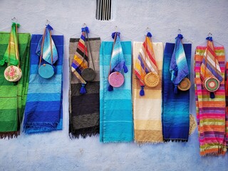 Scarf and handbag set hanging on the wall, strolling in Chefchaouen, the blue city of Morocco