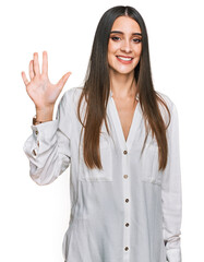 Young beautiful woman wearing casual white shirt showing and pointing up with fingers number five while smiling confident and happy.