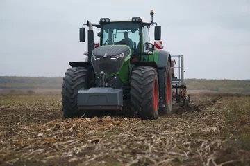 Fotobehang Tractor working in the field. Autumn tillage. Deep ripping with powerful tractor © Юрій Тарасовський