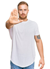 Young irish man wearing casual clothes doing stop sing with palm of the hand. warning expression with negative and serious gesture on the face.