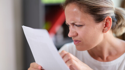 Fototapeta Focused female trying read text, squinting to see more clearly obraz