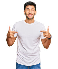 Young handsome man wearing casual white tshirt looking confident with smile on face, pointing oneself with fingers proud and happy. - obrazy, fototapety, plakaty