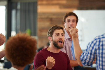 It pays to be a winner. Shot of a group of designers looking excited during an informal meeting. © Laflor/peopleimages.com
