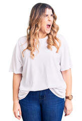 Fototapeta premium Young caucasian woman wearing casual clothes angry and mad screaming frustrated and furious, shouting with anger. rage and aggressive concept.