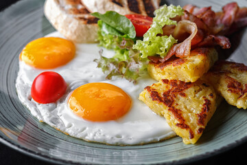 fried eggs with bacon, salad and toast