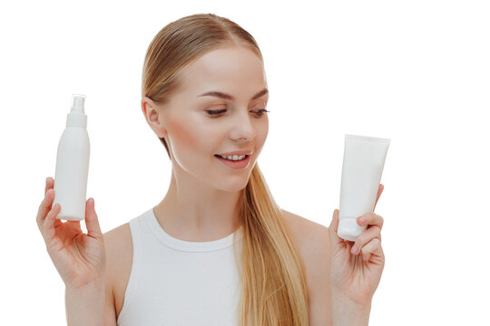 Beautiful blonde girl with a bottle of shampoos in hands. Girl with shiny and long hair. Woman long hair. Woman hold bottle shampoo and conditioner. Woman holding shampoo bottle.