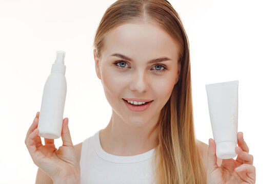 Beautiful blonde girl with a bottle of shampoos in hands. Girl with shiny and long hair. Woman long hair. Woman hold bottle shampoo and conditioner. Woman holding shampoo bottle.