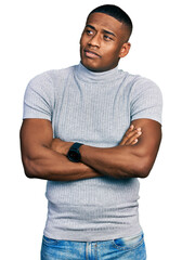 Young black man wearing casual t shirt looking to the side with arms crossed convinced and confident