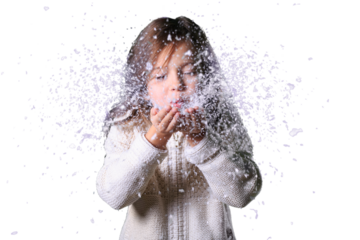 Christmas, x-mas, people, happiness concept - happy girl in winter clothes blowing on snow