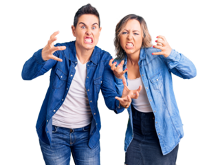 Couple of women wearing casual clothes shouting frustrated with rage, hands trying to strangle, yelling mad