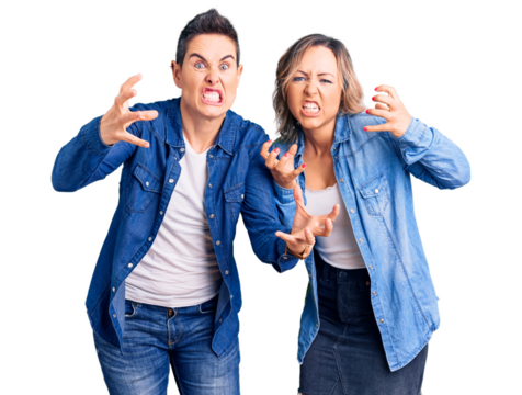 Couple of women wearing casual clothes shouting frustrated with rage, hands trying to strangle, yelling mad