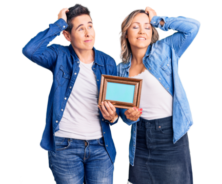 Couple of women holding empty frame smiling confident touching hair with hand up gesture, posing attractive and fashionable