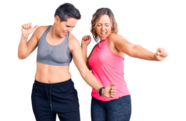 Couple of women wearing sportswear dancing happy and cheerful, smiling moving casual and confident listening to music