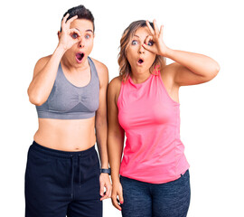 Couple of women wearing sportswear doing ok gesture shocked with surprised face, eye looking through fingers. unbelieving expression. - Powered by Adobe