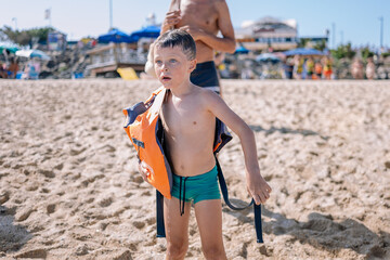 Little boy standing on sandy beach